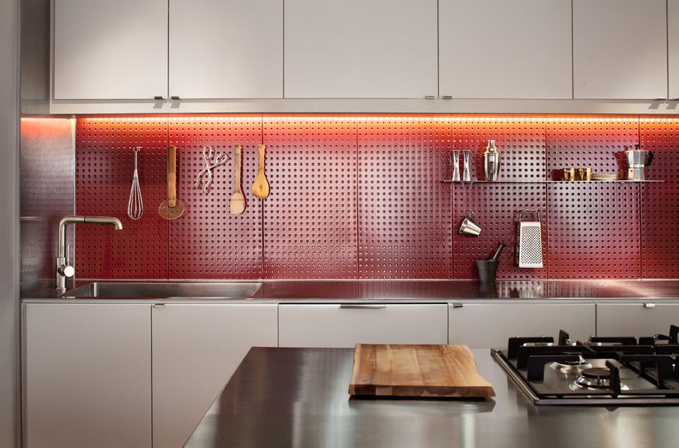 دکوراسیون آشپزخانه کوچک مدرن با کابینت های سفید که از پگ بورد برای آویزان کردن وسایل آشپزی در آن استفاده شده است